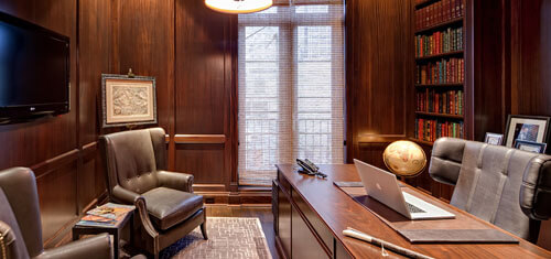 Picture of an office representing the facilities of Top Plastic Surgeons in San José, Costa Rica.  The picture shows a beautiful wood finished interior with an executive desk and chairs.