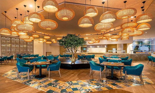 Picture of an elegant hotel lobby in San José, Costa Rica.   The picture shows an ornate ceiling with golden lighting and blue tables and chairs.