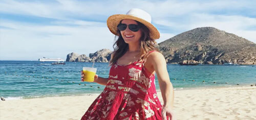 Picture of an attractive woman on a beautiful Jaco beach, enjoying a sunny day.  The woman has on a red and white dress with a beautiful blue Jaco sky in the background.